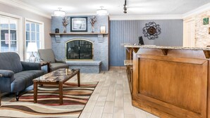 Un salon avec une cheminée, un canapé, une table basse et un meuble en bois.