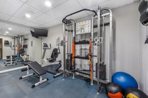 A gym with various exercise equipment, including a bench, weight machines, and a cable machine. - Best Western Inn Florence (Florence)