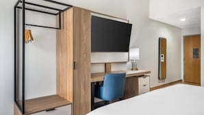 A hotel room with a bed, a desk with a chair, a wardrobe, a TV, and a mirror. - Best Western Inn Florence (Florence)