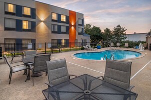 Una piscina al aire libre de temporada, sillones reclinables de piscina