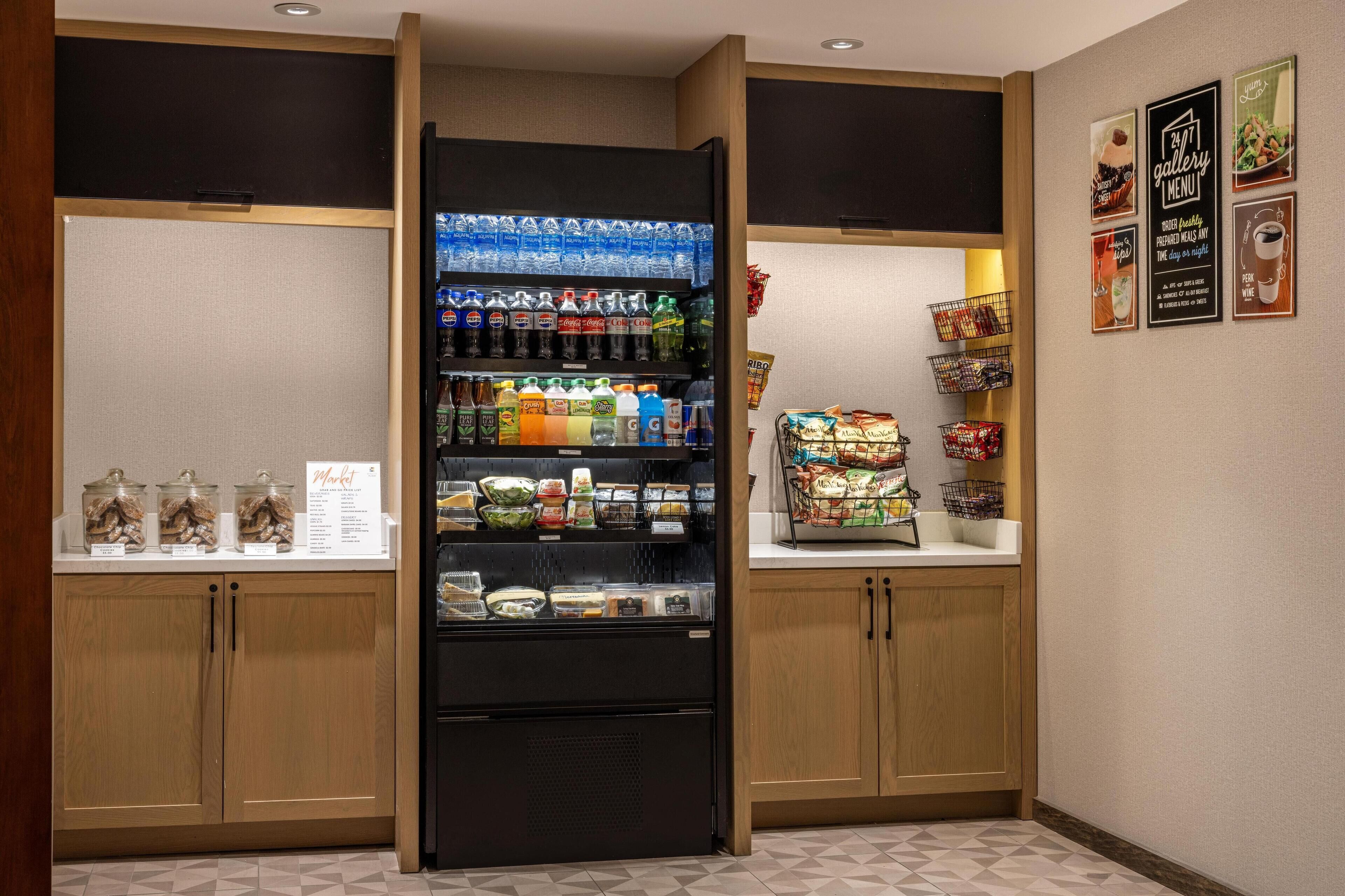 Un área de comida autoservicio con bebidas refrigeradas, bocadillos y comidas preparadas.