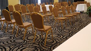 A conference room with rows of chairs, tables, and a patterned carpet. - Red Roof Inn Atlanta Airport NE - Conley (Conley)