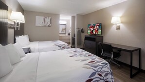 A hotel room with two beds, a desk, a TV, and a lamp. - Red Roof Inn Atlanta Airport NE - Conley (Conley)