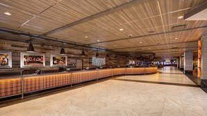 Eine geräumige Lobby mit einer langen Rezeption, Holzboden und gerahmten Bildern an der Wand.