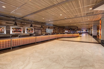 A spacious coffee shop with multiple seating areas, a counter with various items, and a Starbucks logo. at Nugget Casino Resort