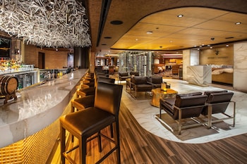A conference room with a large table, leather chairs, patterned carpet, wooden ceiling, and a