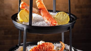 A seafood platter with shrimp, lobster, and oysters on ice.