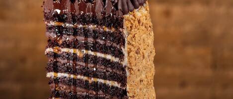 A slice of layered cake with chocolate and caramel on a white plate.