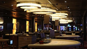 Eine Hotelhalle mit mehreren Sitzbereichen, einem Empfangstresen und einer großen Chandelier.