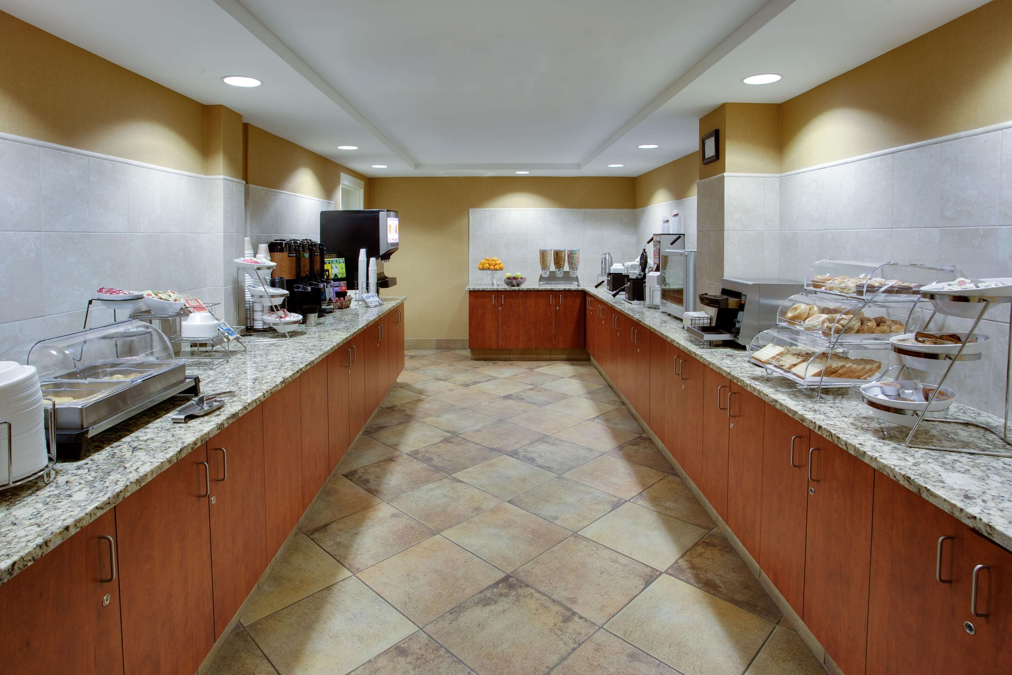 A hotel kitchen with a buffet setup, including a coffee station and various food items displayed on the counters.