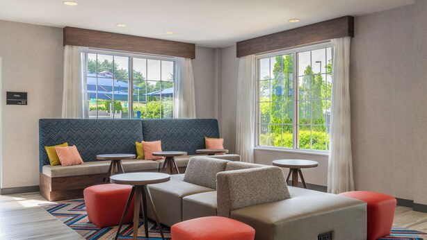 Een moderne hotelkamer met een zithoek, een tafeltje en een bank.