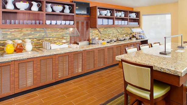 A modern kitchen with wooden cabinets, a granite countertop, and a breakfast bar. - HYATT house Mt. Laurel (Mount Laurel)