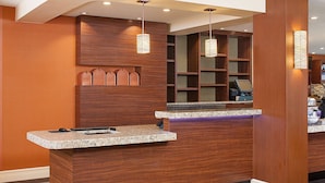 A reception desk with a wooden finish, a computer, and a telephone. - HYATT house Mt. Laurel (Mount Laurel)