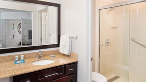 A bathroom with a sink, mirror, and a glass shower enclosure. - HYATT house Mt. Laurel (Mount Laurel)