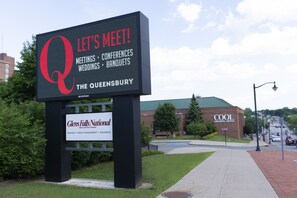 Une enseigne pour «The Queensbury», avec un grand logo en forme de «Q», indiquant qu’il s’agit d’un lieu où l’on peut organiser des réunions, des conférences, des mariages et des banquets.