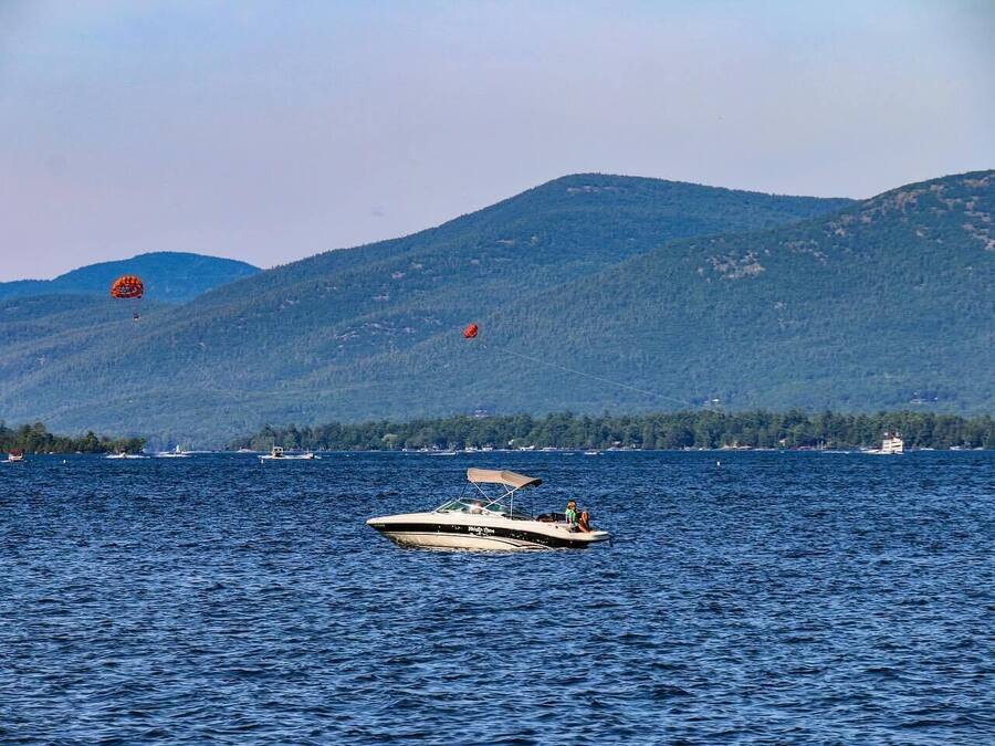 Un barco en un lago tranquilo con montañas al fondo.