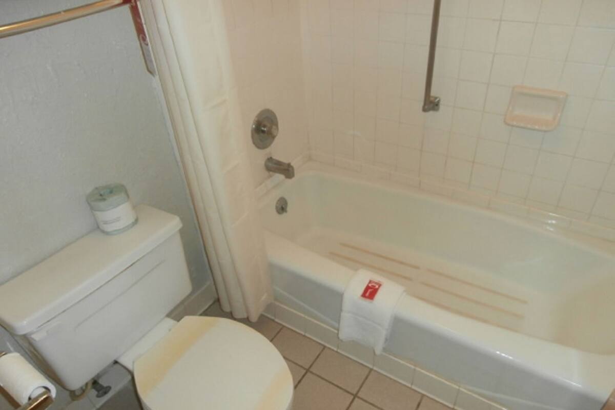 Ein Badezimmer mit Toilette, Badewanne und Duschvorhang.