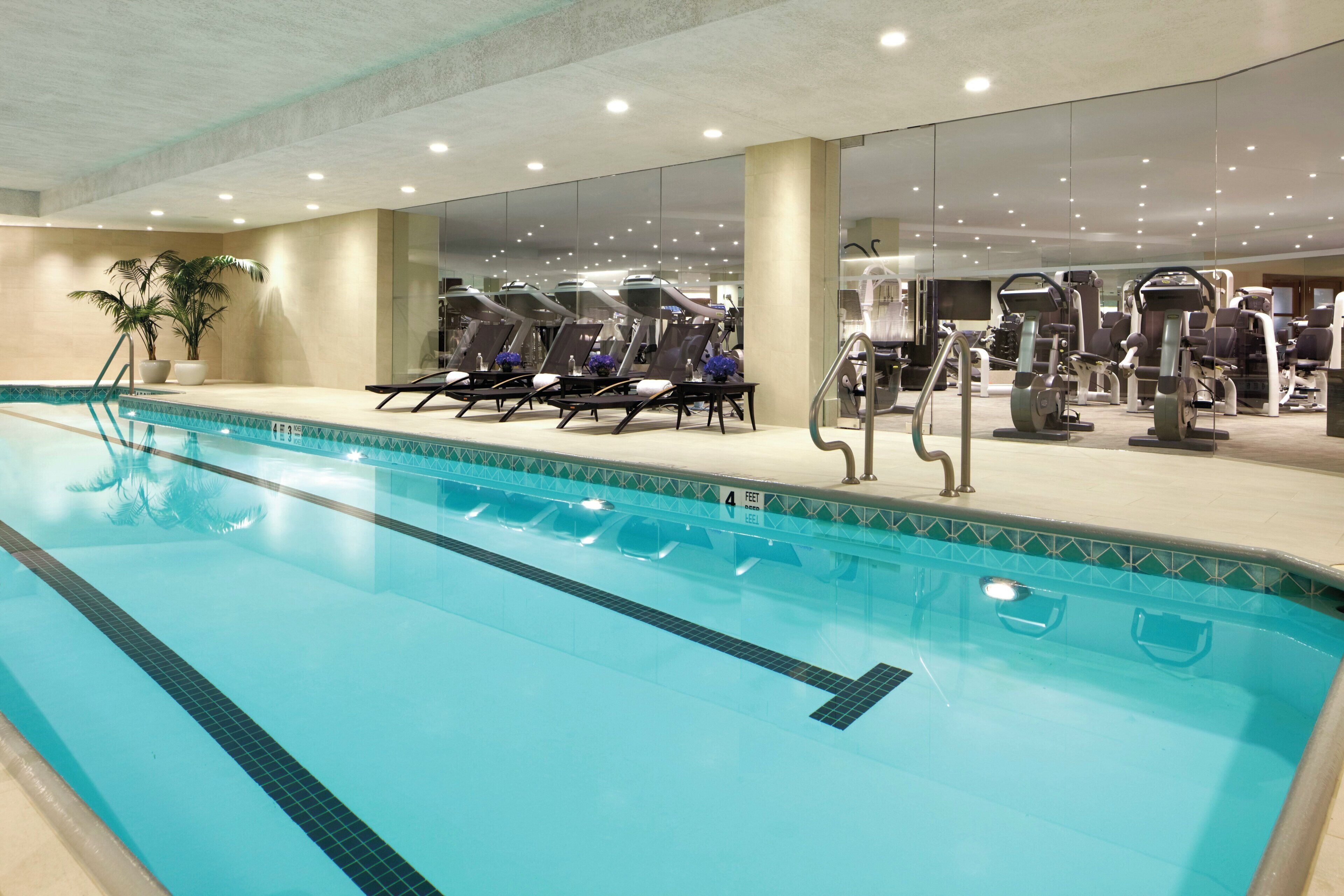 A swimming pool with lounge chairs and exercise equipment.