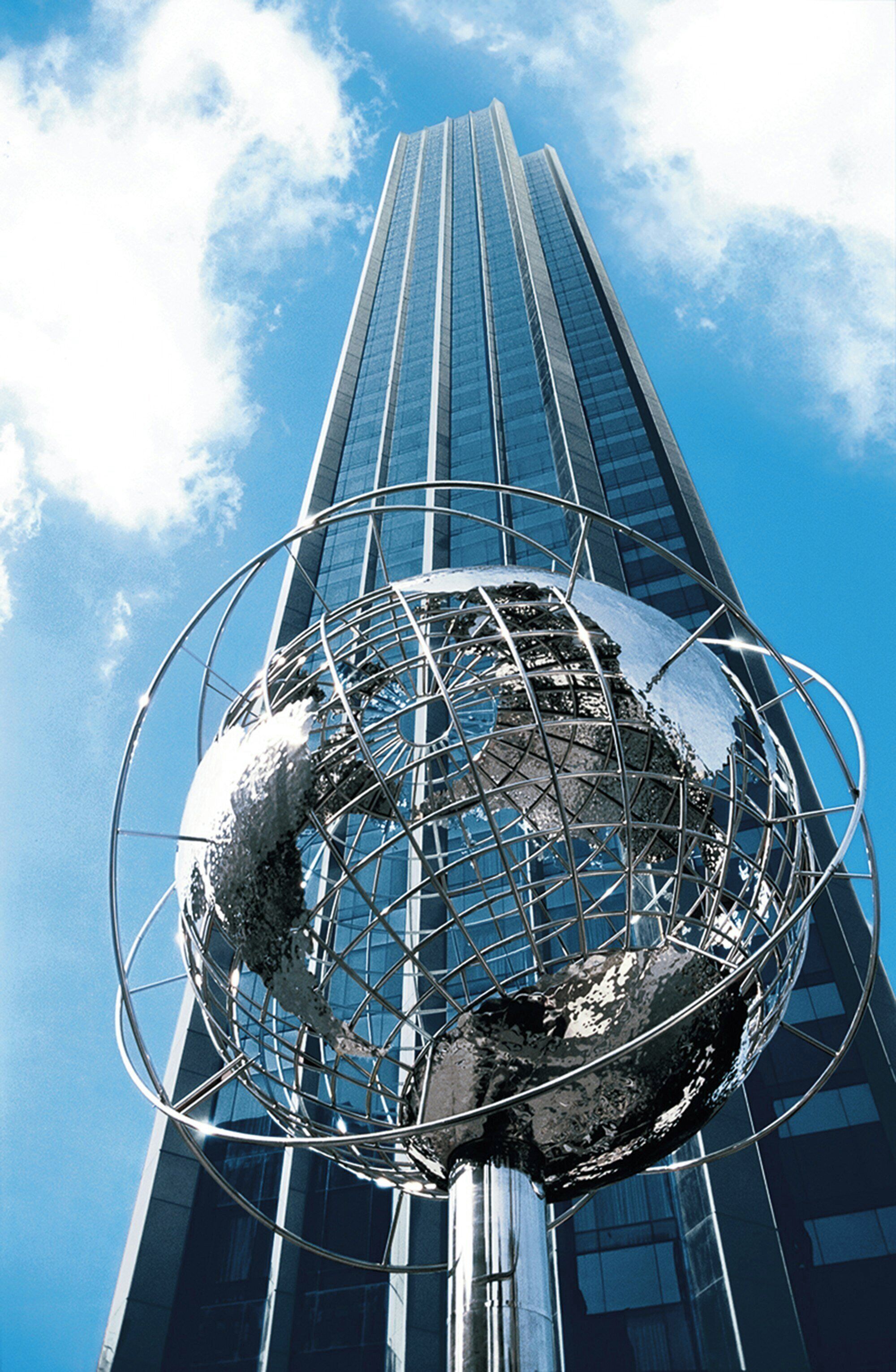 Un rascacielos moderno con una estructura esférica al frente.
