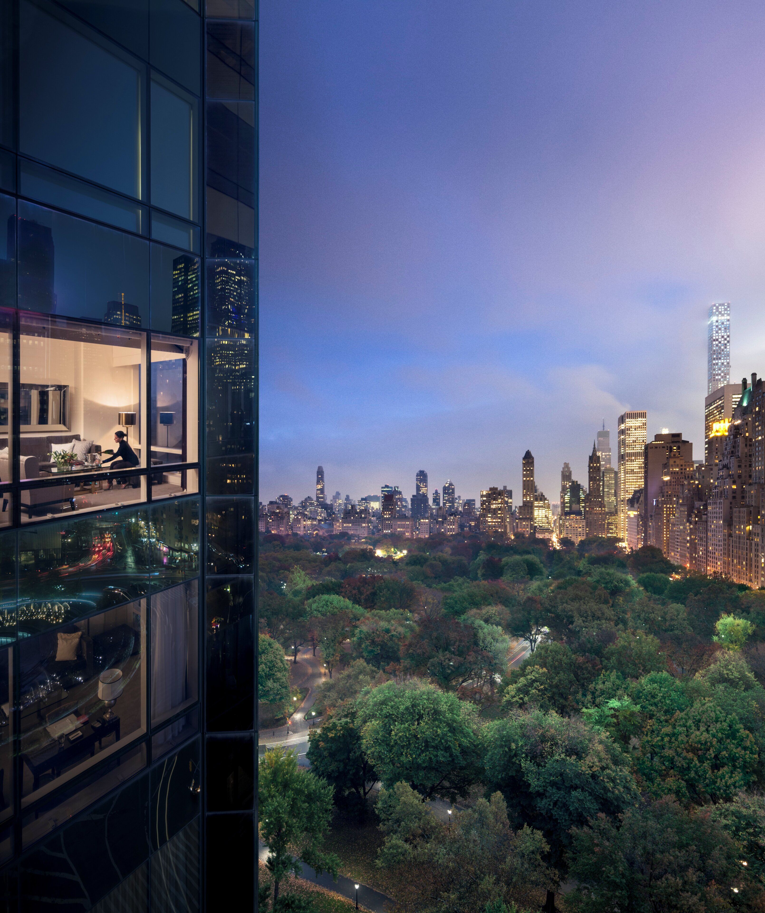 A high-rise building with a view of a city skyline and a park below.