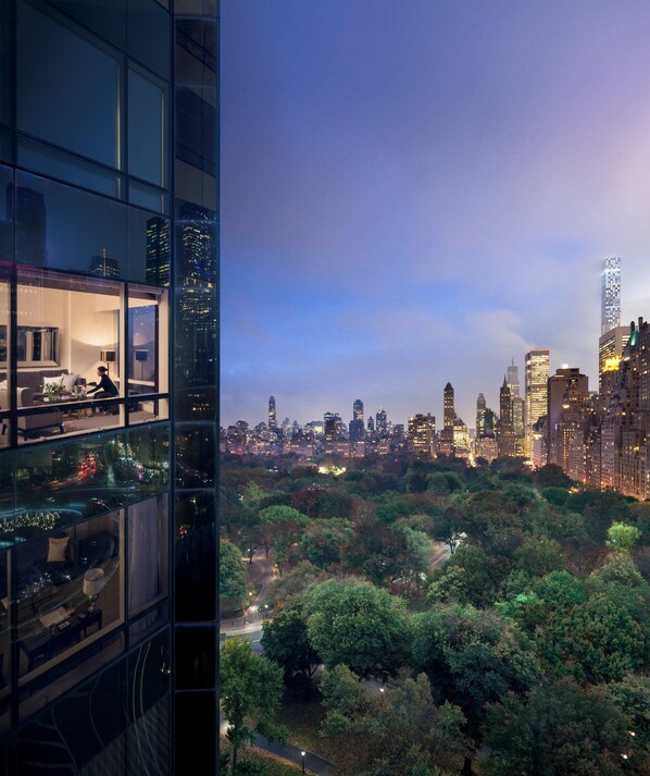 A high-rise building with a view of a city skyline and a park below.