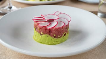 A plate with a layered dish, possibly a tartare, on a white plate.