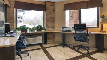 A modern office space with a desk, two chairs, a computer, and a printer.