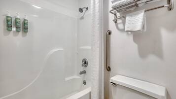 Un baño con ducha, inodoro y toallero.