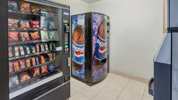 A vending machine with snacks and a Pepsi cooler.