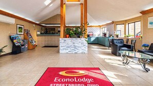 A spacious lobby with a reception desk, a glass coffee table, and seating area. - Econo Lodge Cleveland Southeast - Kent (Streetsboro)