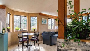 A spacious kitchen with a dining area, large windows, and a stone accent wall. - Econo Lodge Cleveland Southeast - Kent (Streetsboro)