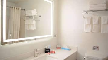 A bathroom with a sink, mirror, towel rack, and toilet.