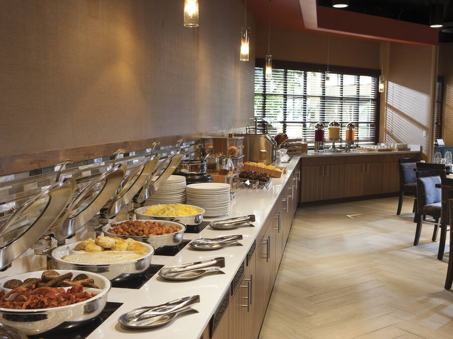 A buffet setup with various food items and serving utensils.
