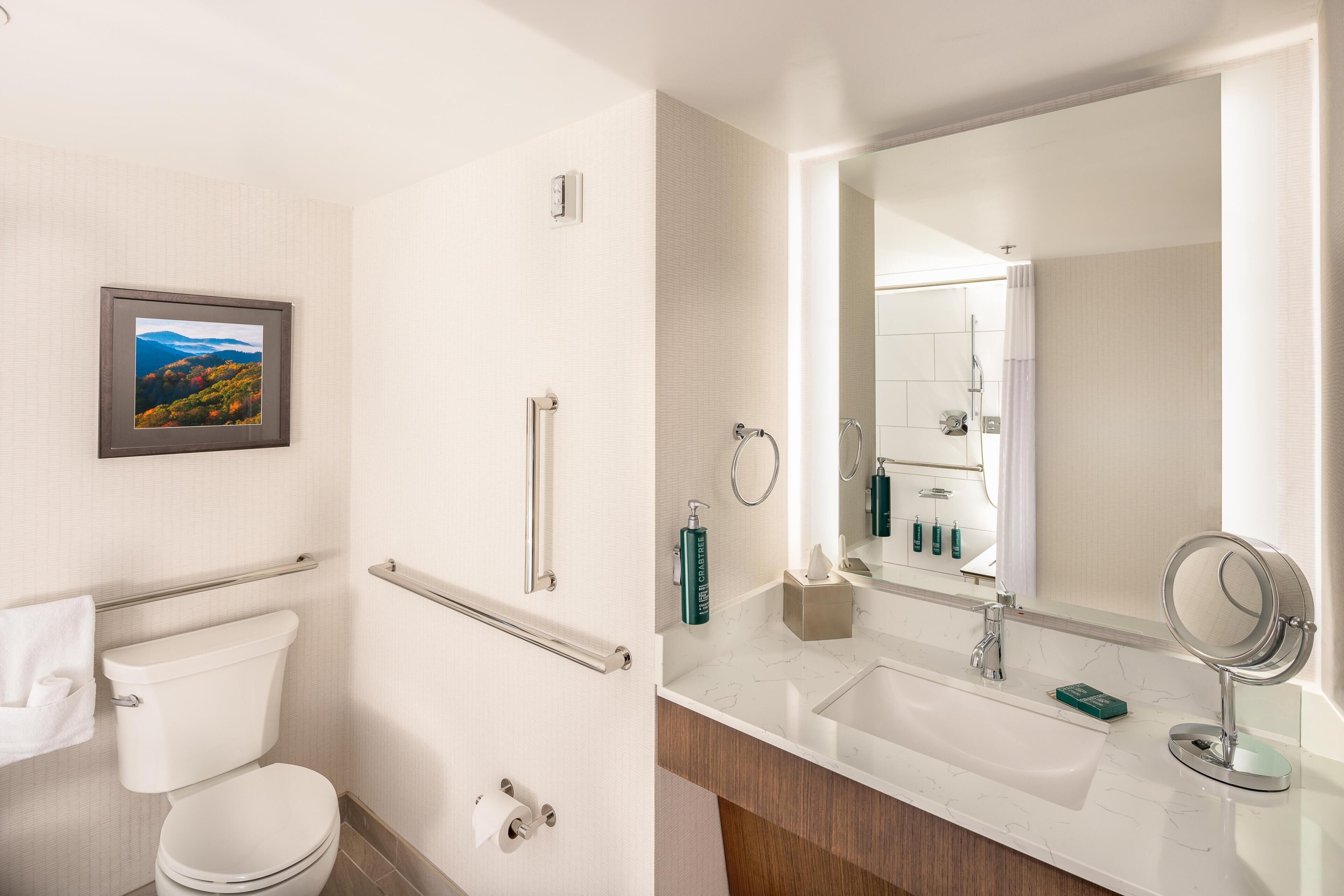 Un baño moderno con inodoro, bidé, lavamanos y espejo.