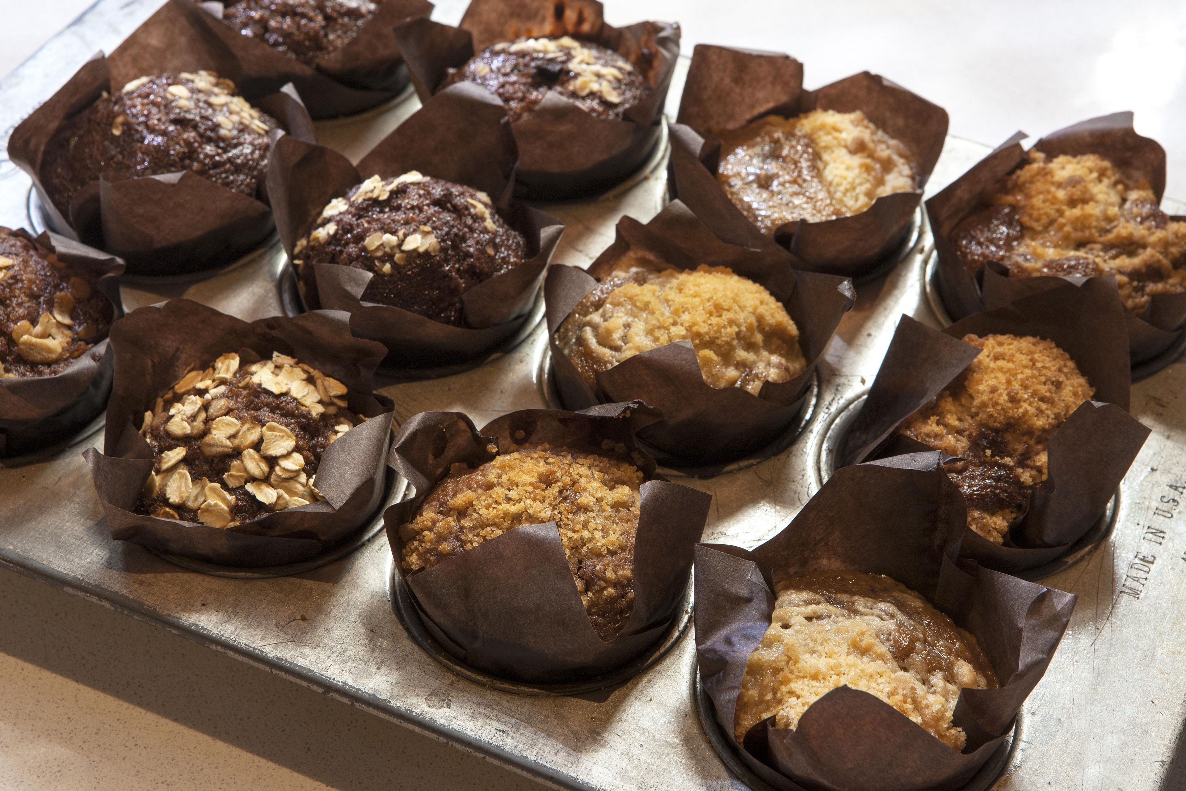A tray of baked goods, possibly muffins, in individual paper cups.