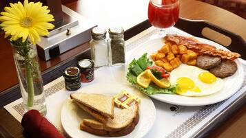 A breakfast tray with toast, eggs, bacon, sausages, and a drink.