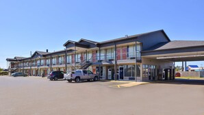 Un motel con diverse camere, un parcheggio e una stazione di servizio.