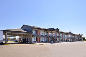 A motel with multiple floors, a covered parking area, and a visible staircase.