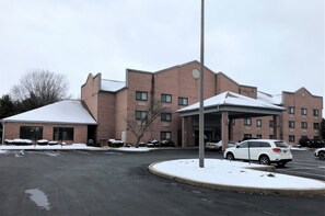 A multi-story brick building with a covered entrance and a parking lot. - Red Roof Inn & Suites Chestertown (Chestertown)