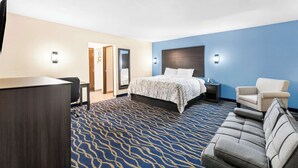 Une chambre d’hôtel avec un lit, un bureau, une chaise et un canapé.