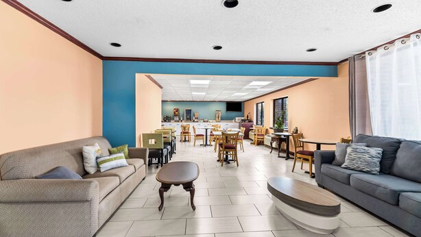 Un vaste espace de vie comprenant un canapé, une table basse et un coin repas avec des chaises et une table.