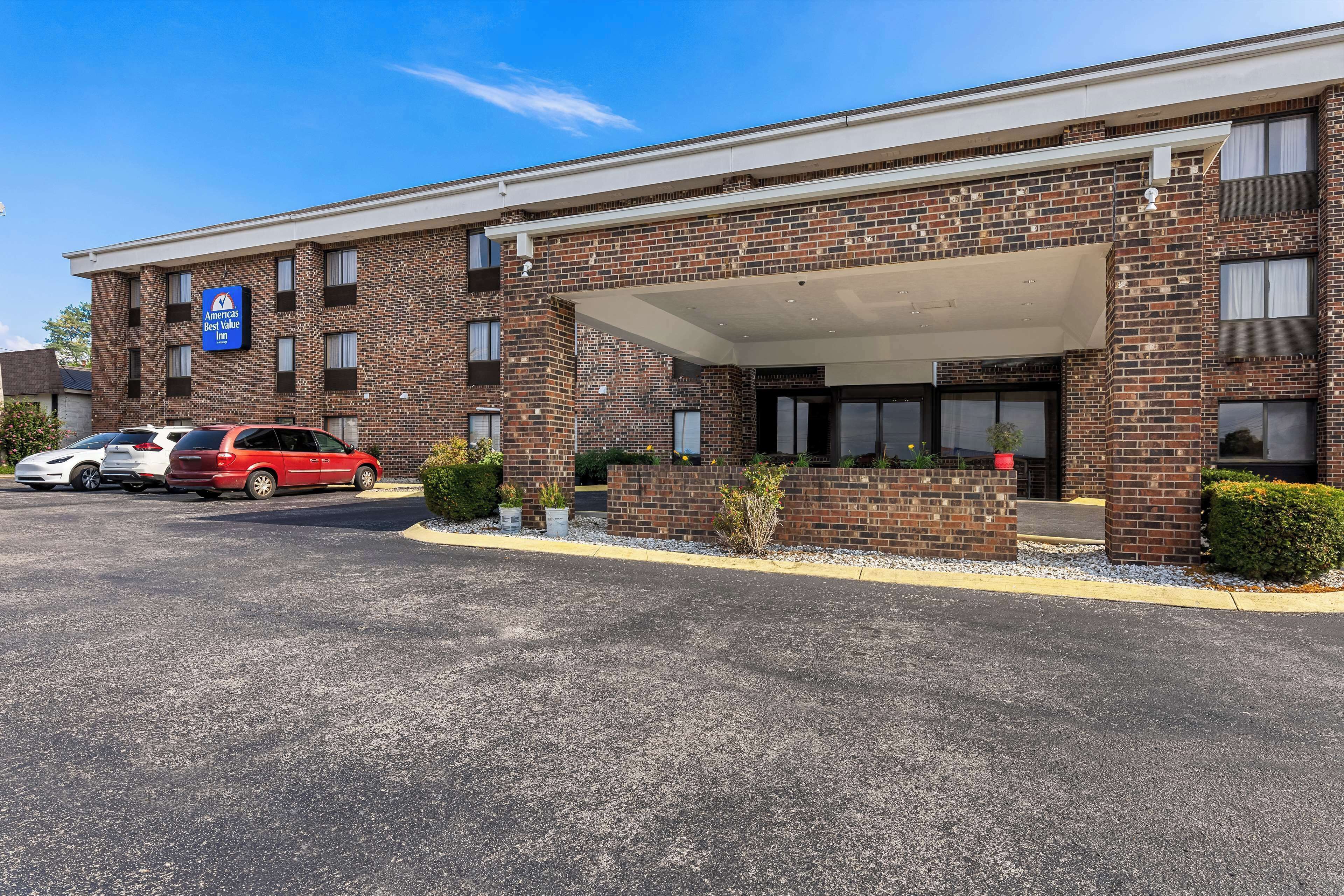 A brick building with a covered entrance and a sign for 'Americas Best Value Inn'.