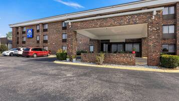 A brick building with a covered entrance and a sign for 'Americas Best Value Inn'.