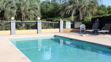 Una piscina al aire libre de temporada, sombrillas