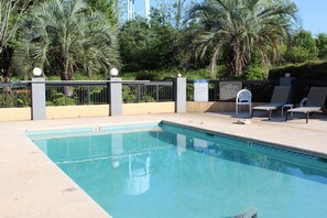 Una piscina al aire libre de temporada, sombrillas