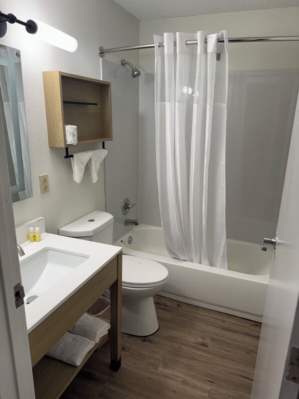 A modern bathroom with a shower, toilet, and sink.