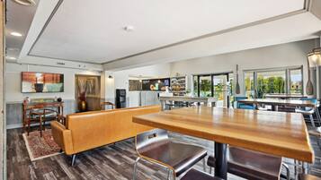 Una cocina moderna con comedor, suelo de madera y ventanas amplias con vistas al exterior.