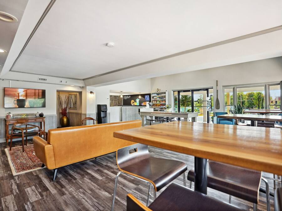 Una cocina moderna con comedor, suelo de madera y ventanas amplias con vistas al exterior.