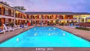 Ein Hotel mit Pool, Liegestühlen und einer überdachten Terrasse.