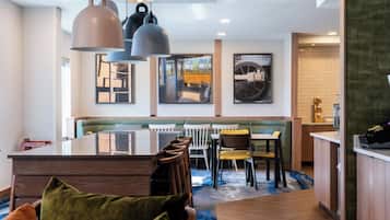 A modern dining area with a central island, wooden chairs, and pendant lighting.
